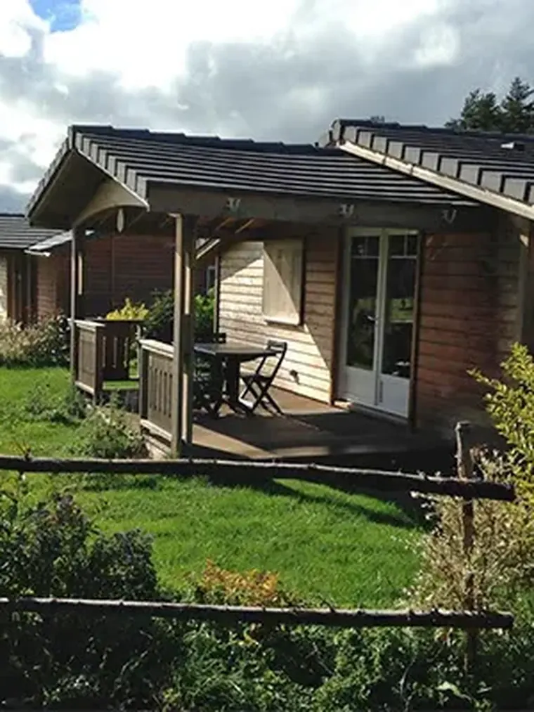 Chalet en bois du Village Équi-Nature avec sa terrasse, à Chalinargues